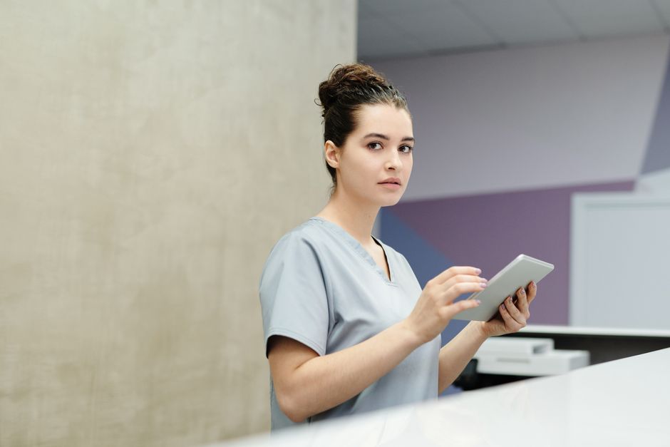 A receptionist reviewing a submission on her tablet at the front desk