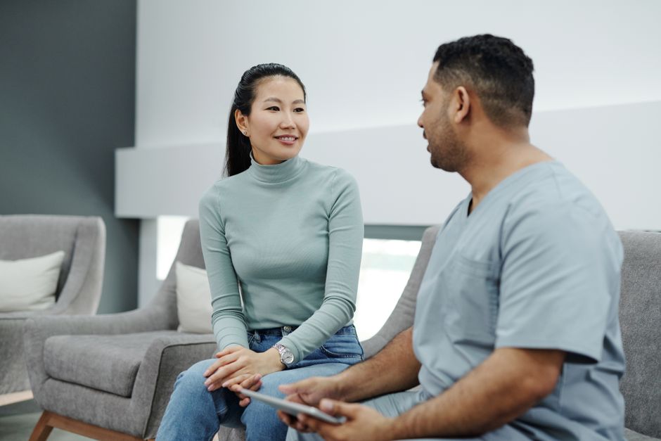 A patient and a clinician going over a form together on a tablet