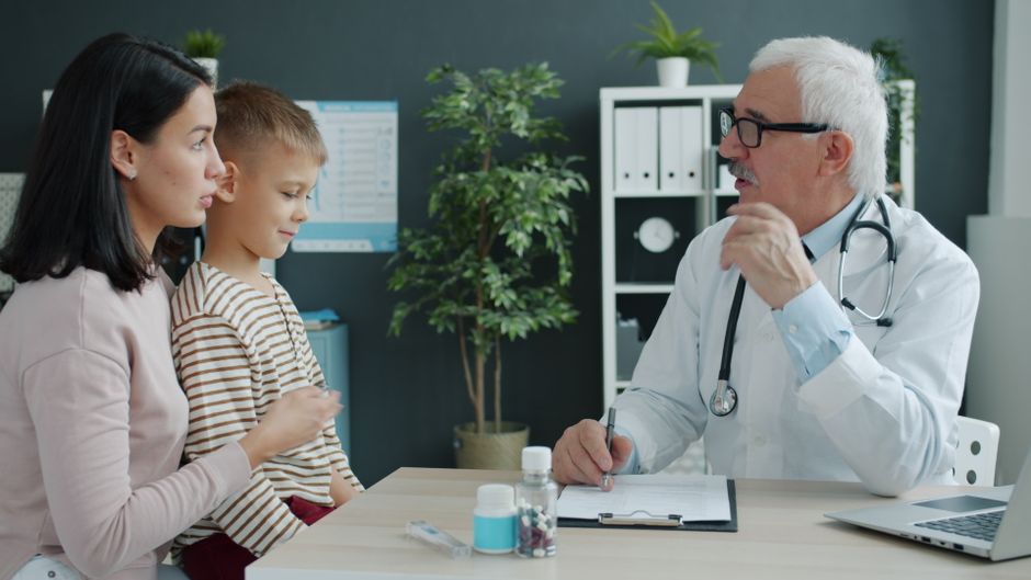 A pediatrician talking with a mother and her son